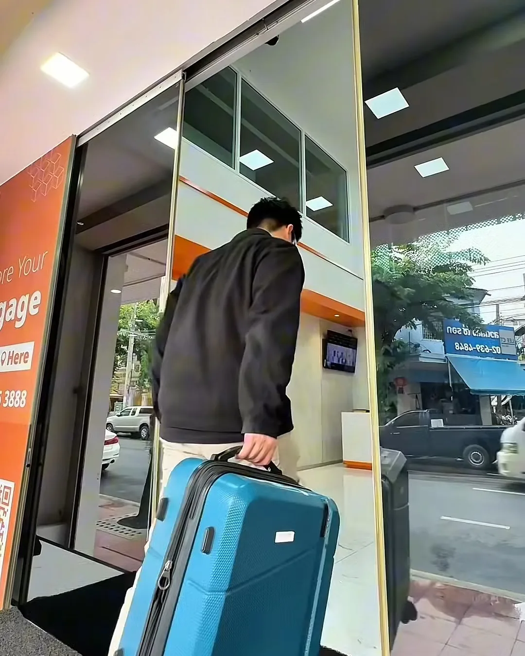 ลากกระเป๋าเดินทางเข้าประตูกระจก LEO Self Storage Chinatown ถนนเจริญกรุง
