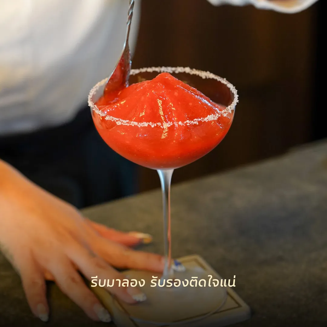 ฟรอเซนค็อกเทลสีแดงในแก้วขอบโรยเกลือ วางบนบาร์