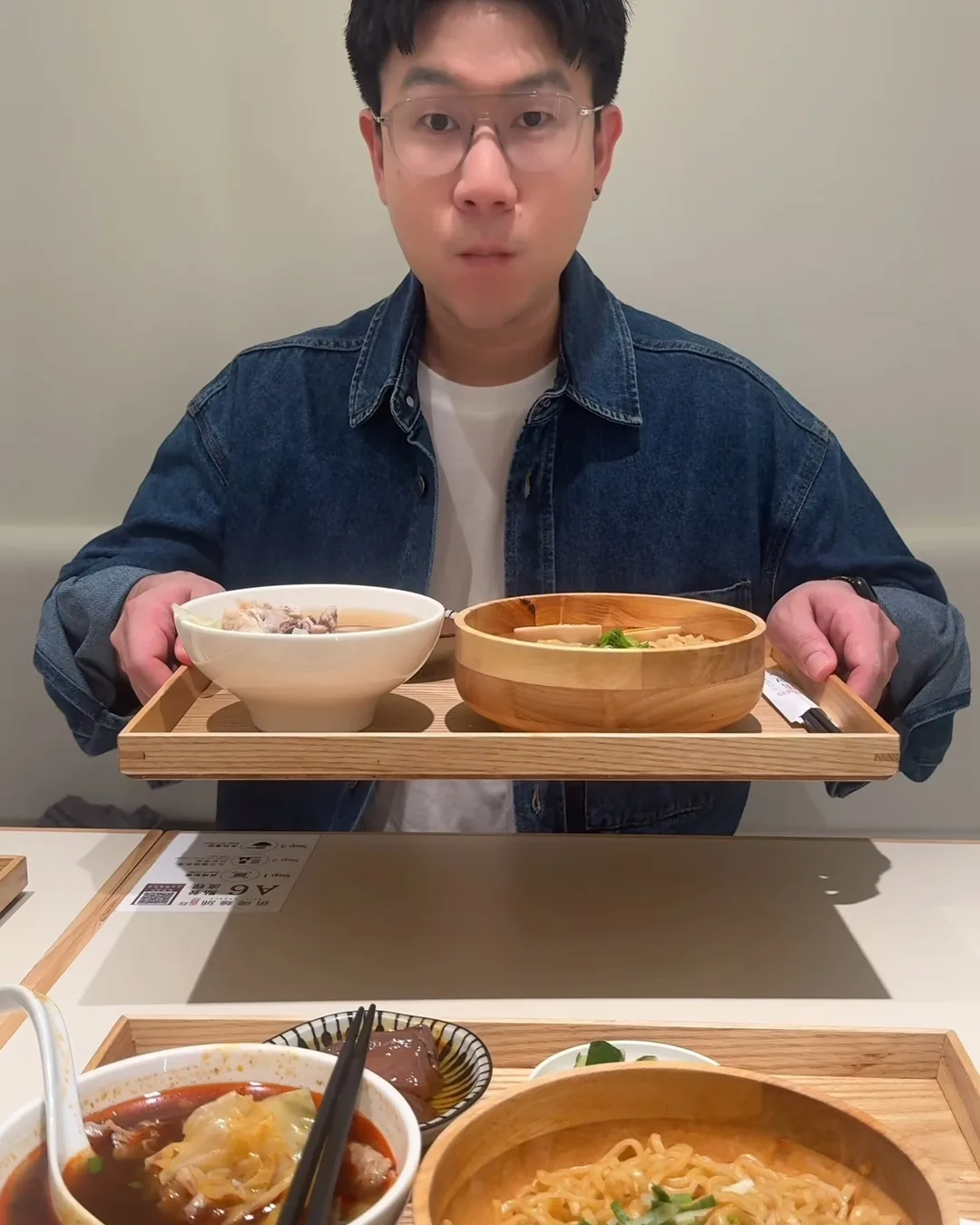 ทีม PewPew ถือถาดไม้ใส่บะหมี่แห้งชามไม้และถ้วยซุป ร้าน Spicy Noodle ไทเป