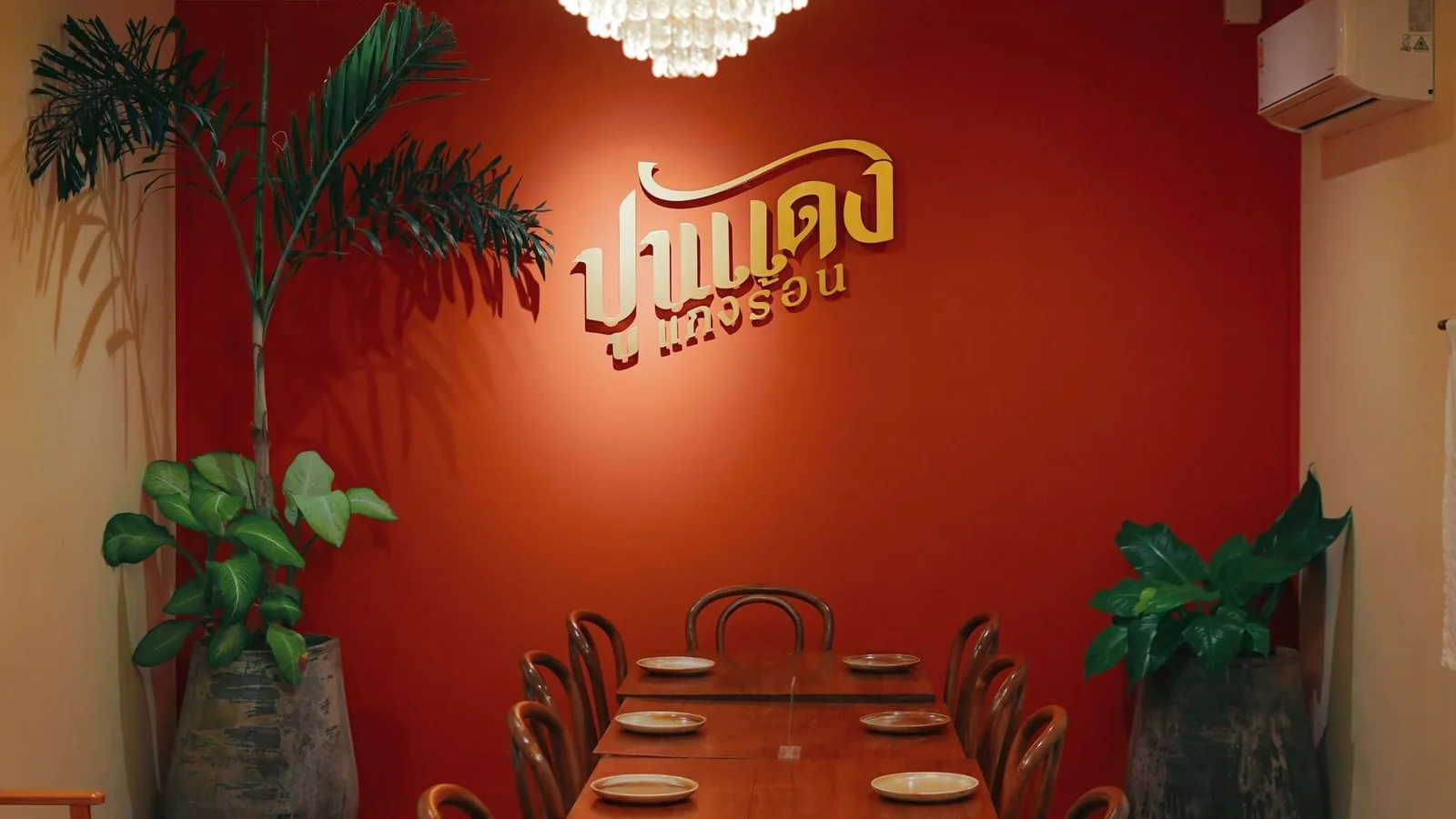 ห้องรับรองผนังสีแดงอิฐ โลโก้ปูนแดงแกงร้อนสีทอง ร้านปูนแดงแกงร้อน สาขาสาทร