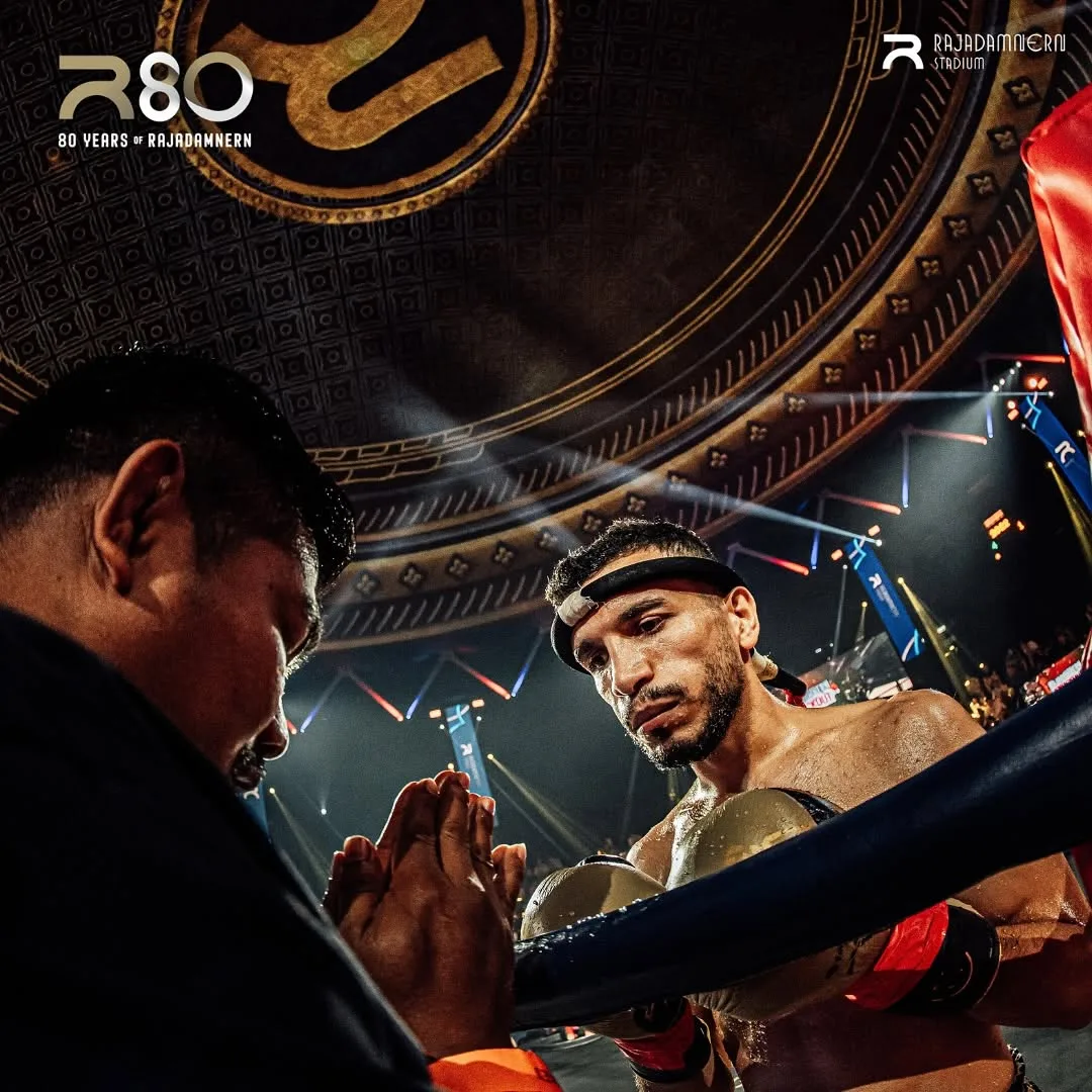 ครูมวยพนมมือคุยกับนักมวยที่มุมเวทีก่อนเริ่มชก เวทีมวยราชดำเนิน
