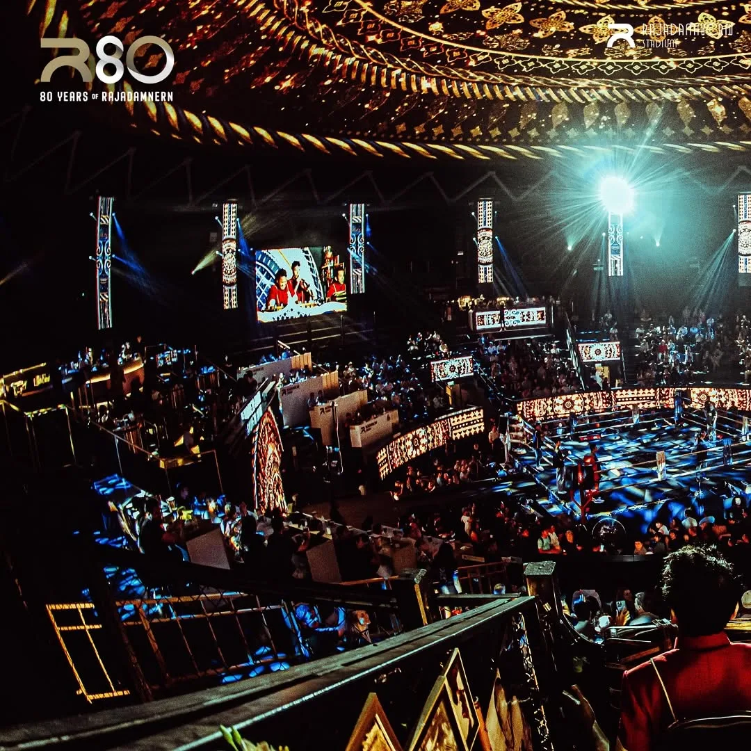 ผู้ชมเวทีมวยราชดำเนินชั้นบนกับจอภาพและไฟสปอตไลต์