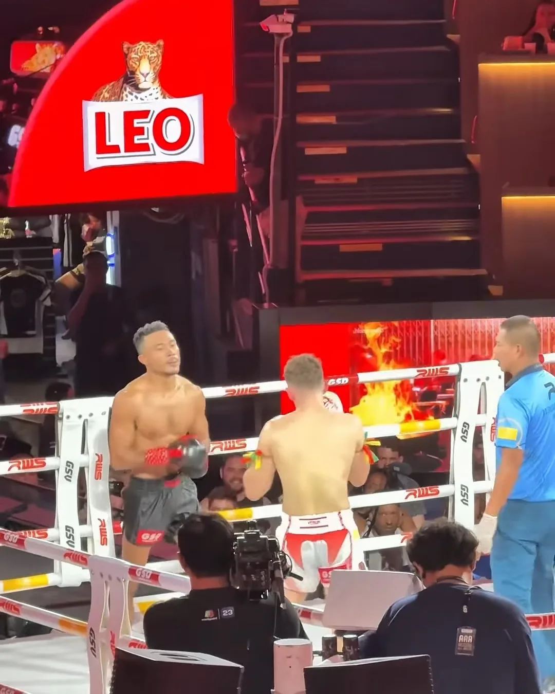 นักมวยสองคนบนเวทีมวยราชดำเนิน มองจากขอบเวที ป้าย LEO สีแดงด้านหลัง