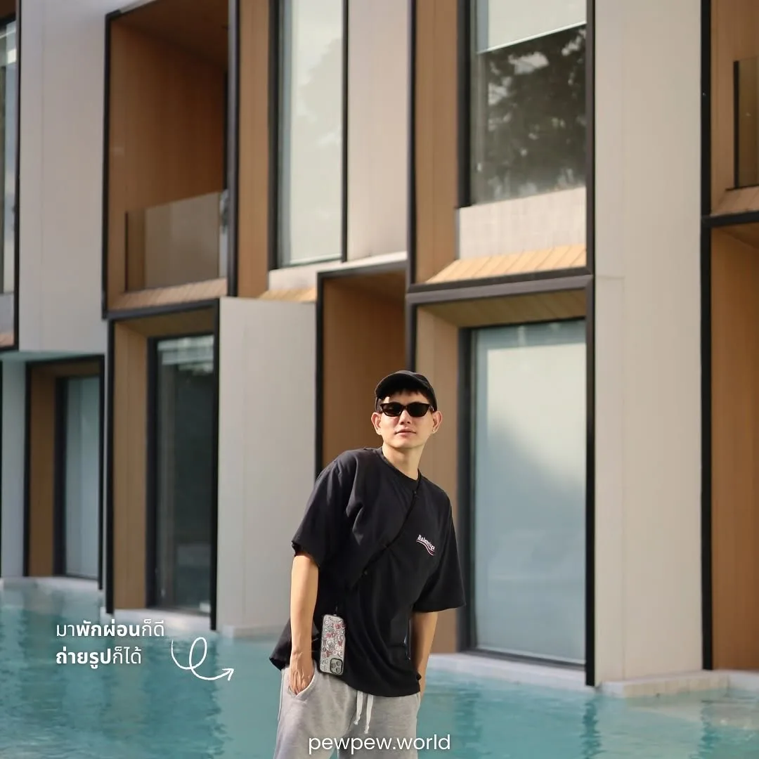 ทีม PewPew ยืนโพสต์ถ่ายรูปบนทางเดินริมสระ หน้าห้อง Pool Access ผนังขาวกรอบไม้ ที่ Riva Vista เชียงราย