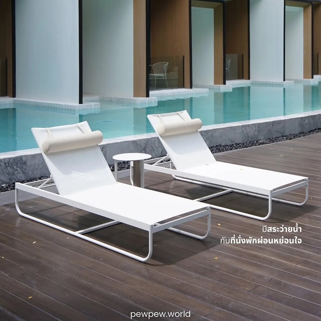 เตียงอาบแดดสีขาวสองตัวบนพื้นไม้ริมสระว่ายน้ำ หน้าห้องพัก Pool Access ที่ Riva Vista