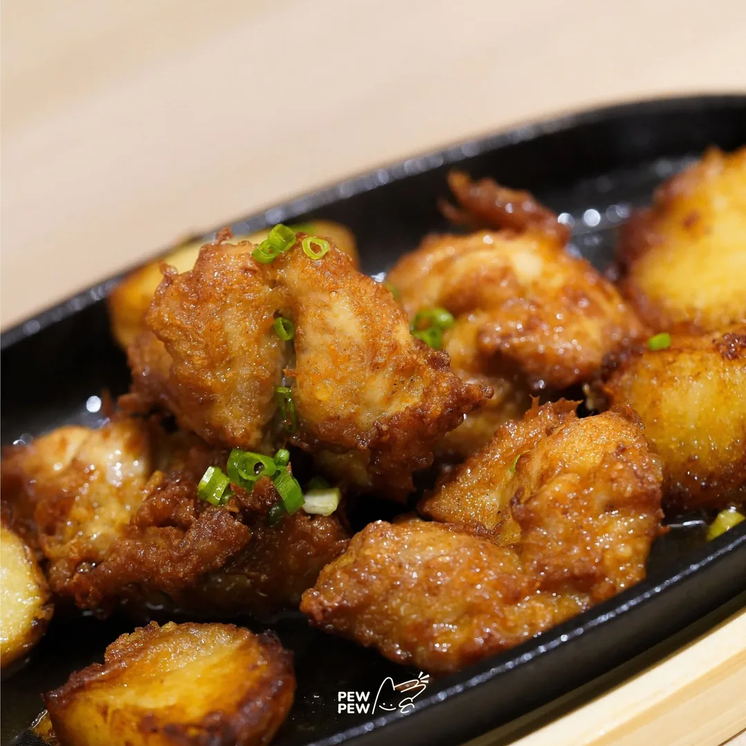 ไก่คาราอาเกะกับมันฝรั่งบนกระทะเหล็กร้อน โรยต้นหอม