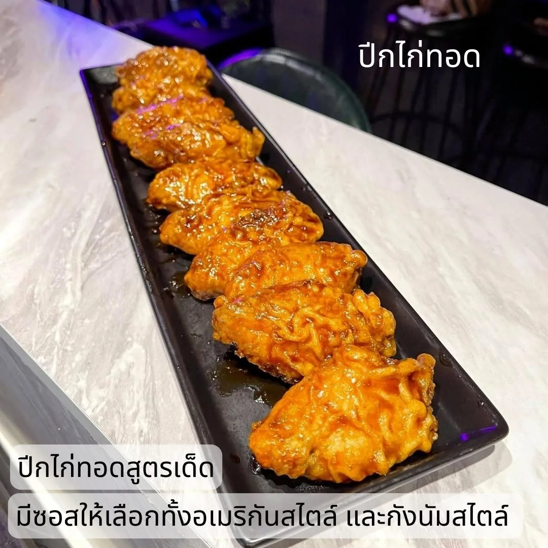 ปีกไก่ทอดเคลือบซอสสีส้มเรียงบนจานยาว