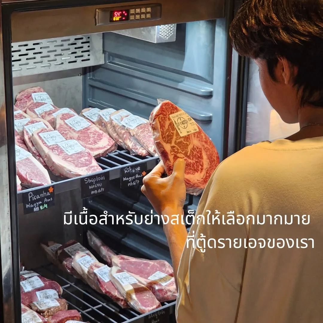 ลูกค้ายืนเลือกเนื้อสเต็กจากตู้เนื้อของร้าน UP A NOTCH