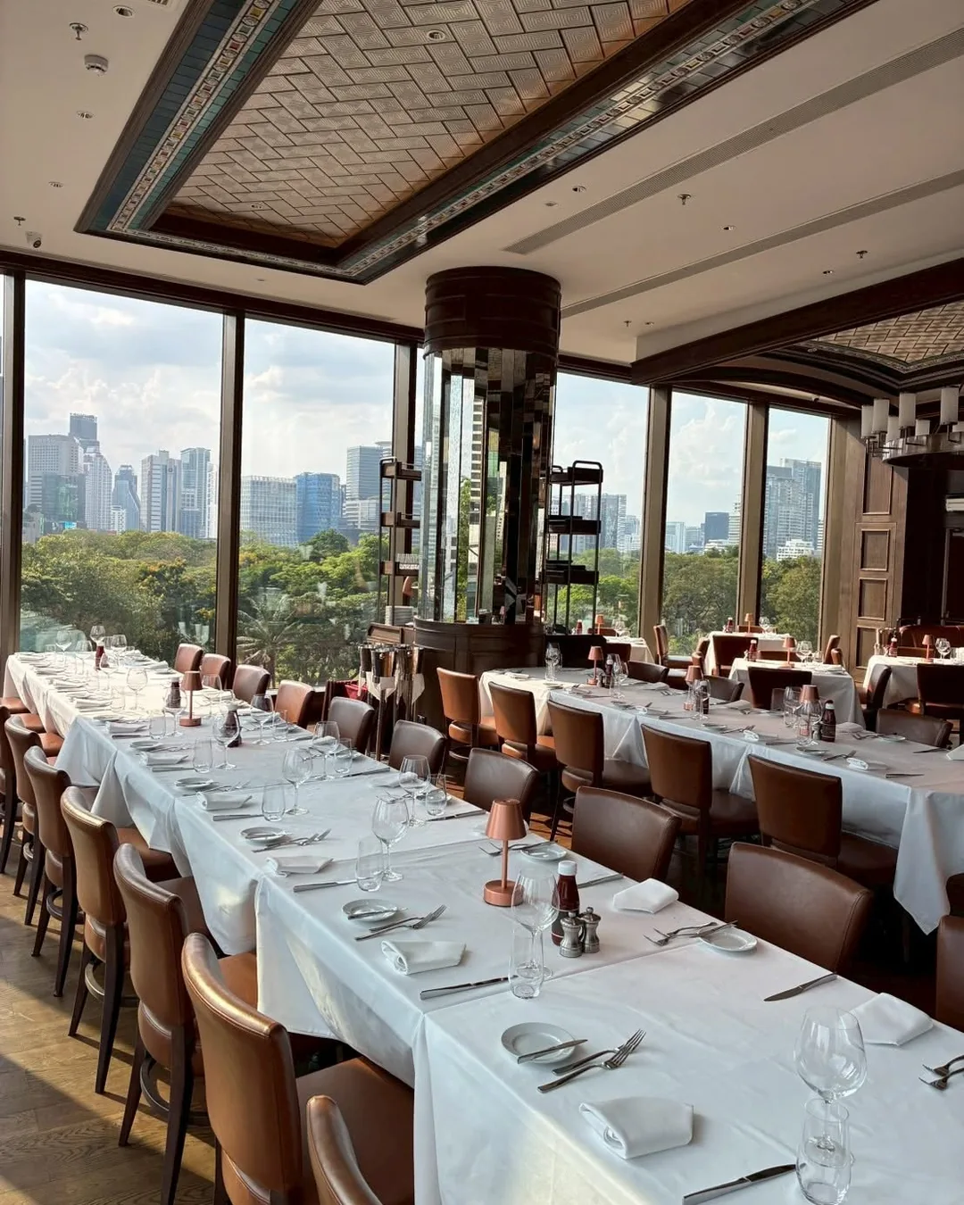 ห้องอาหารยาวริมกระจกของ Wolfgang's Steakhouse วิวต้นไม้และตึกสูง