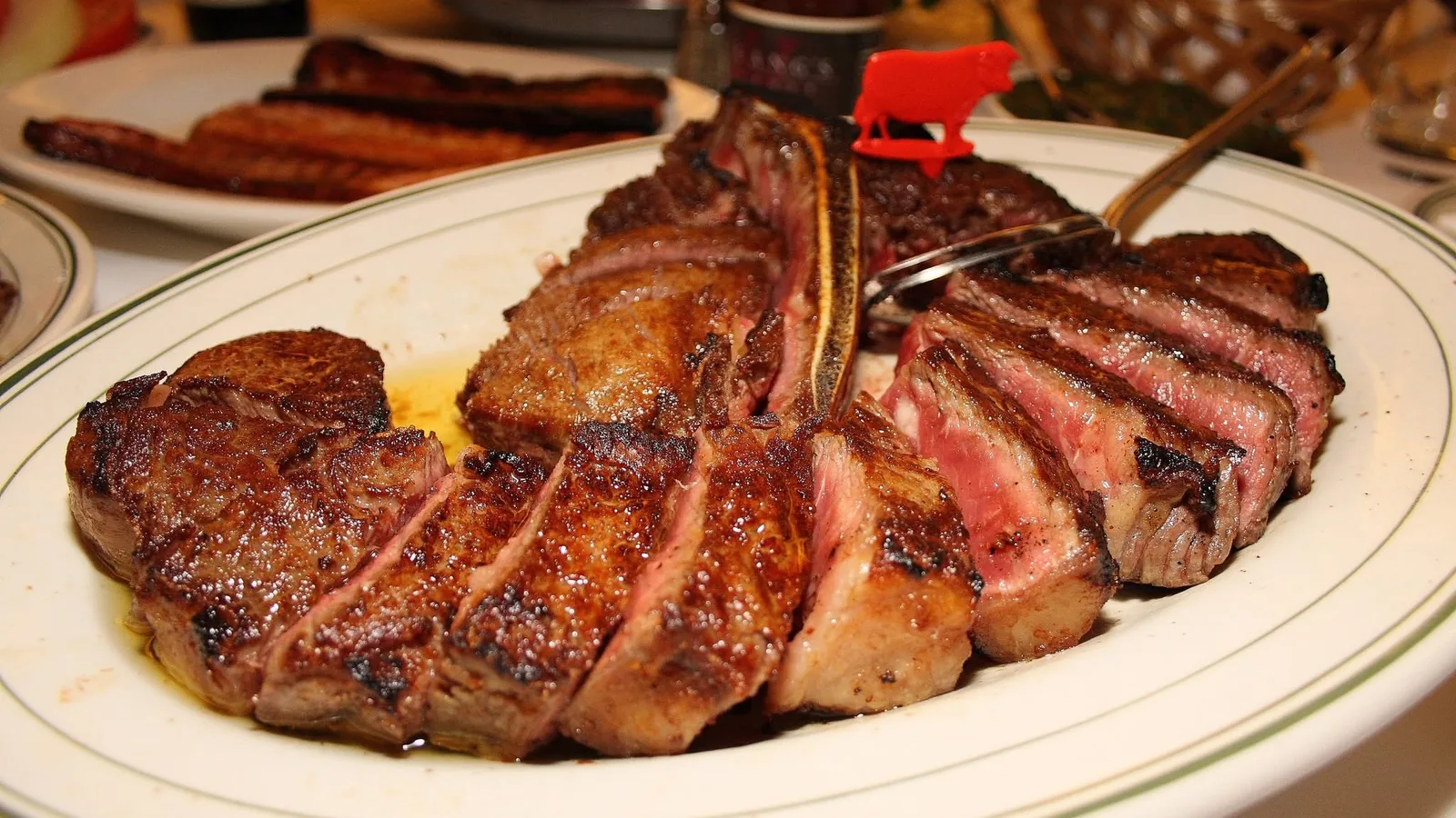 สเต็กพอร์เตอร์เฮาส์ดรายเอจหั่นชิ้นบนจานขาว Wolfgang's Steakhouse ร้านอาหาร One Bangkok