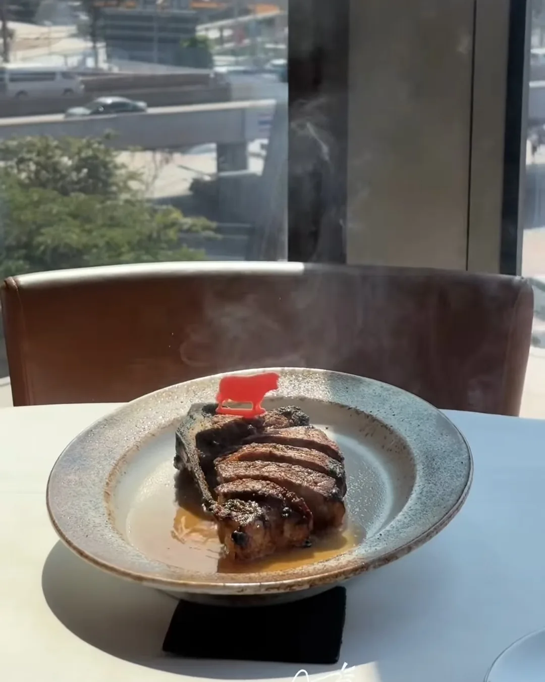 สเต็กสันนอกดรายเอจบนจานริมหน้าต่าง Wolfgang's Steakhouse วิวถนนวิทยุ